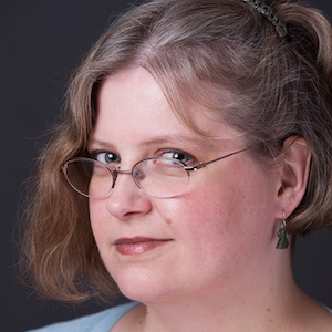 Studio headshot of Stephanie Zvan looking over her glasses.